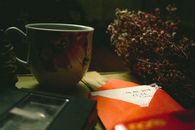 Composition of tea cup with flowers and envelope