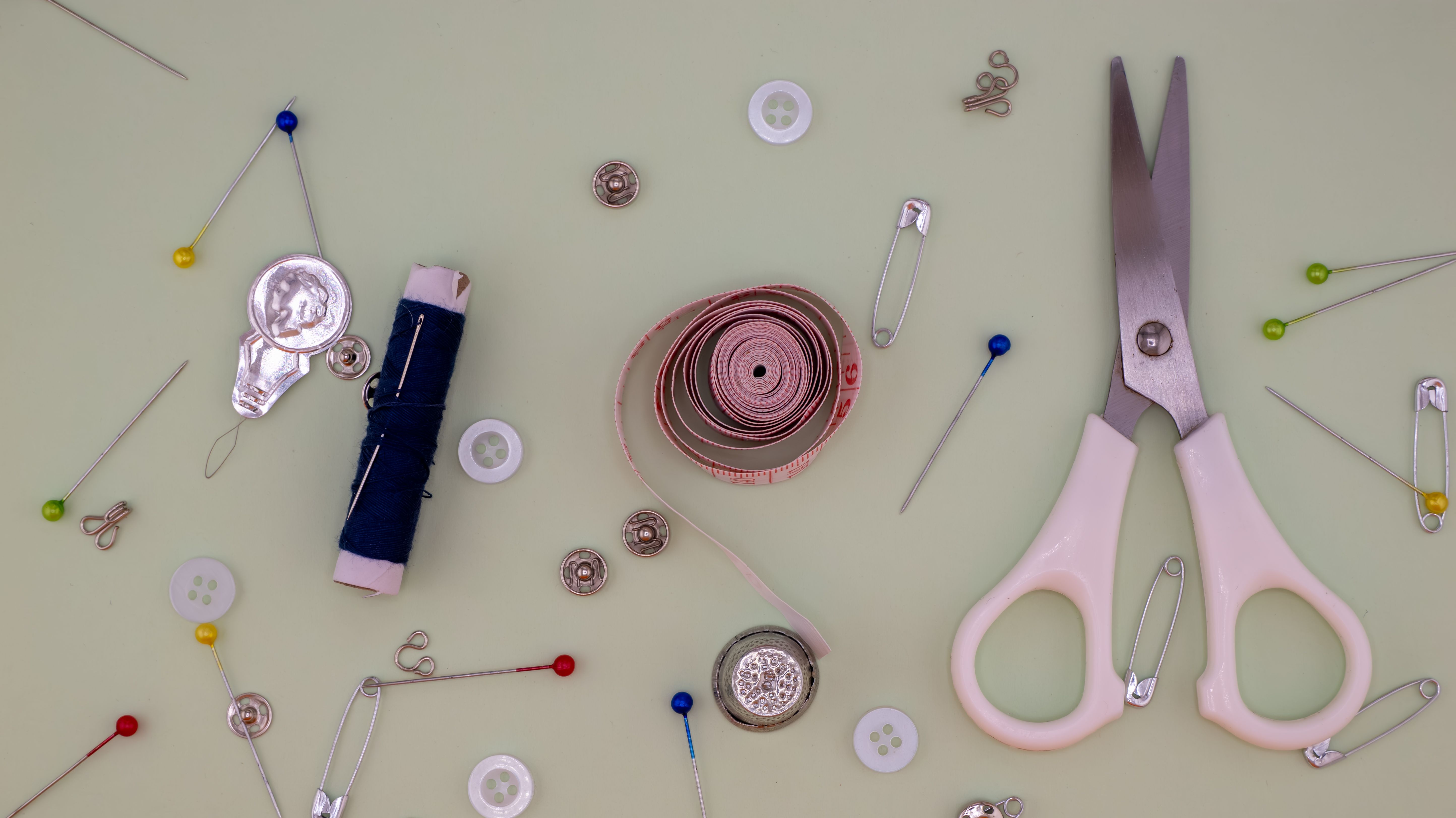 Sewing essentials including scissors, tape measure, and thread displayed neatly on a table.