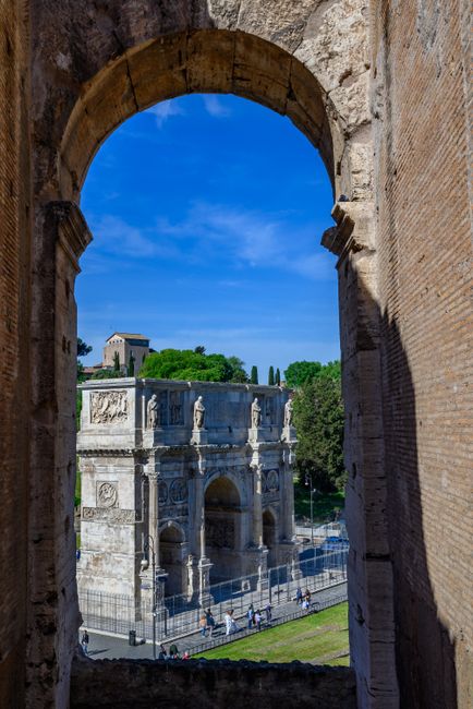 Fotomural El Arco de Constantino enmarcado por ruinas antiguas en Roma, Lacio, ofreciendo una impresionante vista histórica.