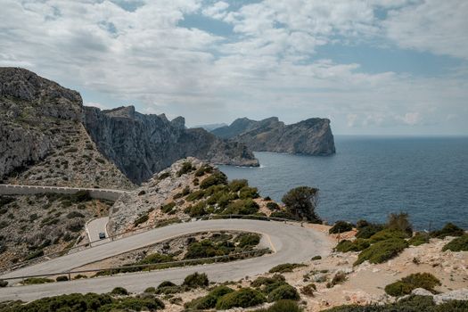 Panoramic view of the winding Cap de Formentor road, with majestic cliffs and the Mediterranean Sea, ideal for a summer road trip.