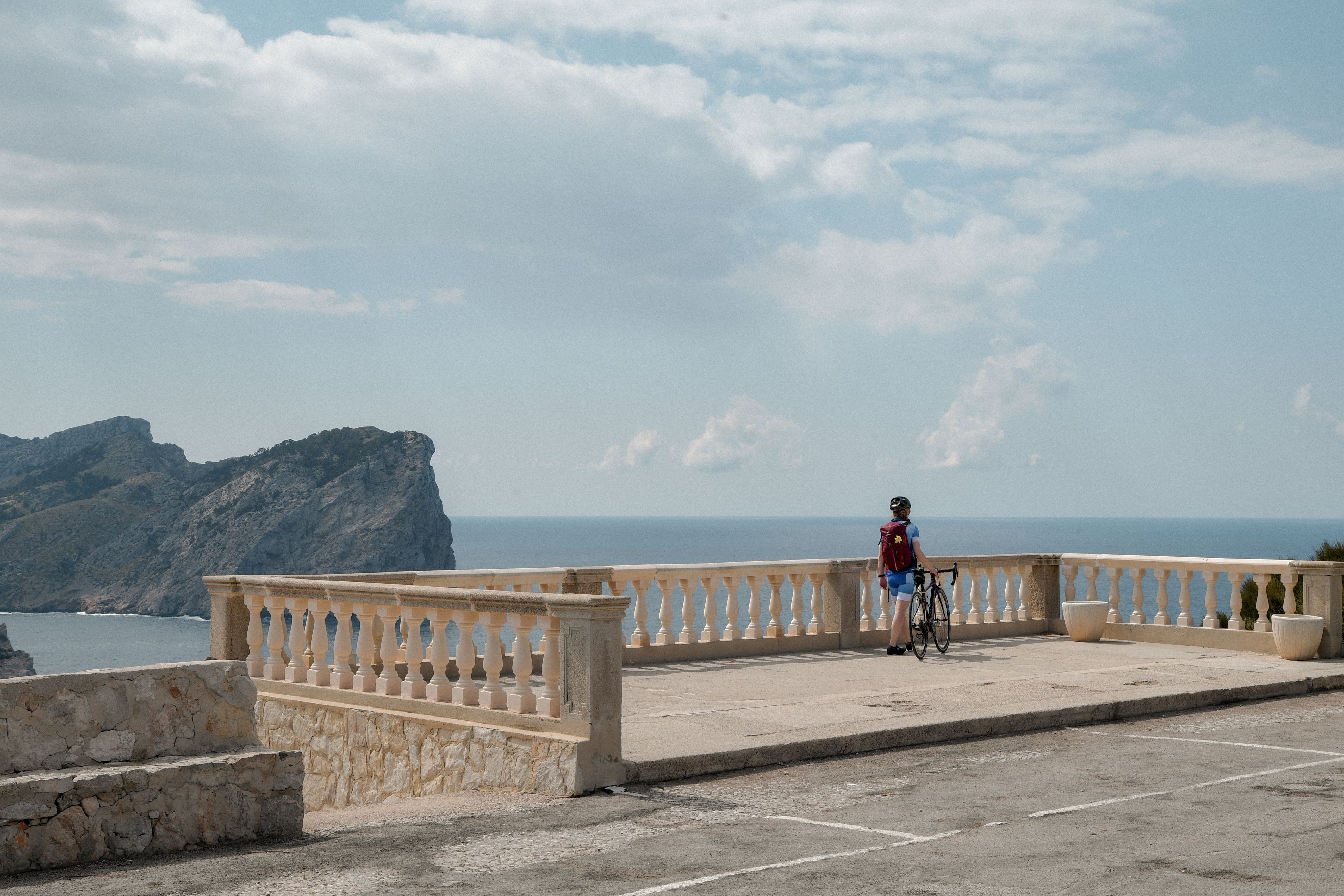Cyclist taking in the breathtaking view at Mirador Es Colomer, Mallorca, Balearic Islands.