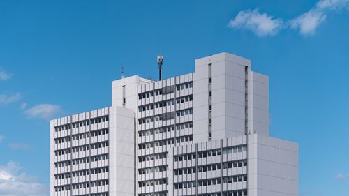 Free A modern white office building with a clear blue sky in the background. Stock Photo