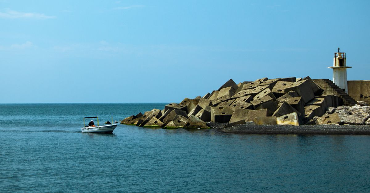 Two diplomats sit in ornate chairs and engage in conversation during an official diplomatic meeting in a formal room.