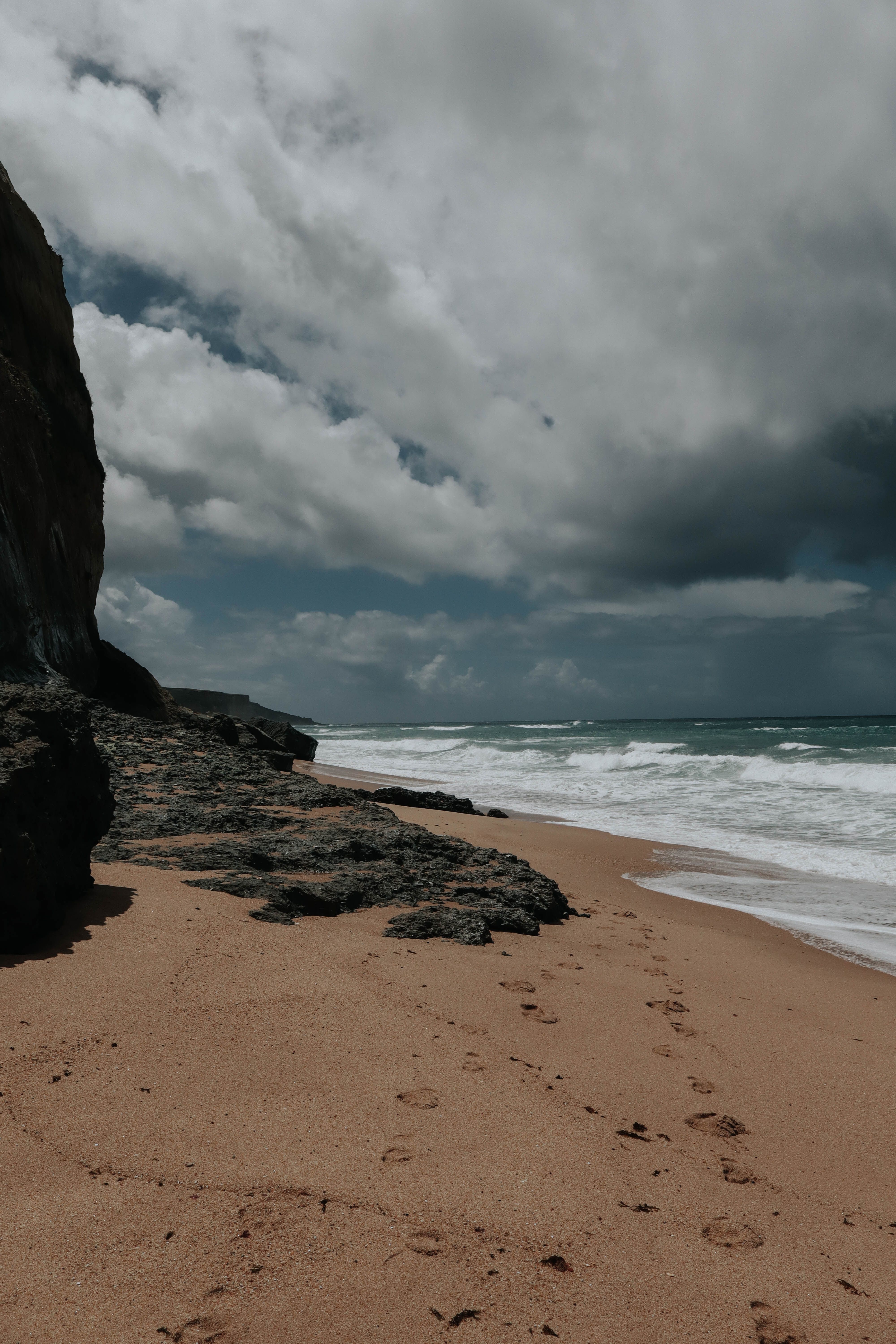 Dramatic Coastal Beach with Rocky Shore · Free Stock Photo