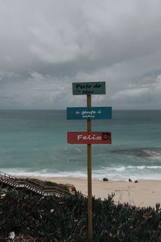 Inspiring signpost by the sea promoting happiness near the ocean.