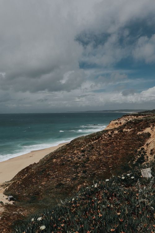 Free Scenic view of rugged cliffs by the ocean under cloudy skies, capturing nature's raw beauty. Stock Photo