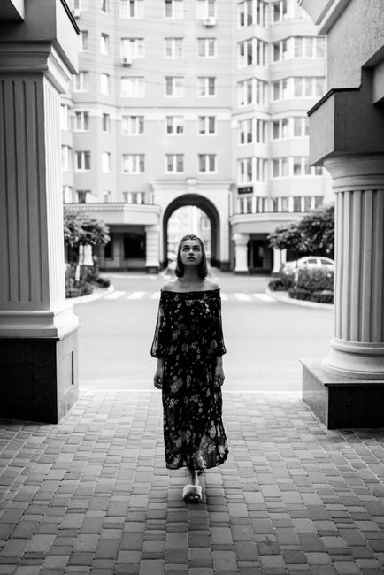Stylish woman walking in urban setting, monochrome fashion shoot.