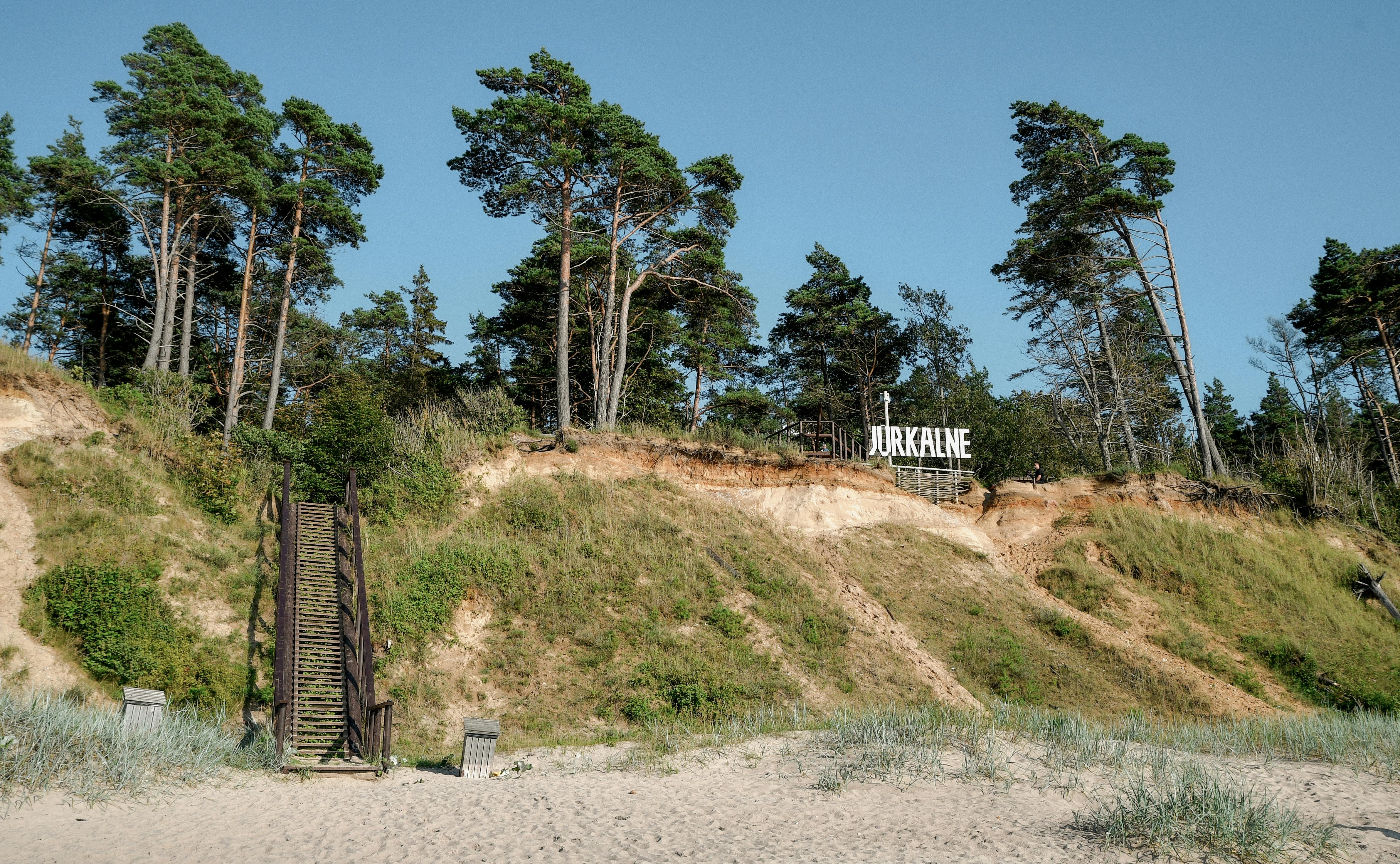Explore the tranquil beauty of Jurkalne's coastal bluffs and lush pine forest in Latvia.