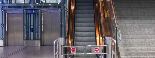 A modern indoor escalator and elevators in a public space, showcasing urban architecture.