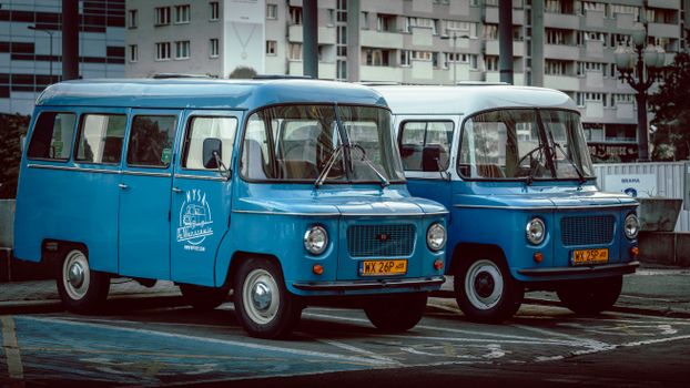 Nysa vans parked in a city street, showcasing vintage automotive style.