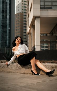 Stylish woman in a chic pose against a modern cityscape, embracing urban fashion.