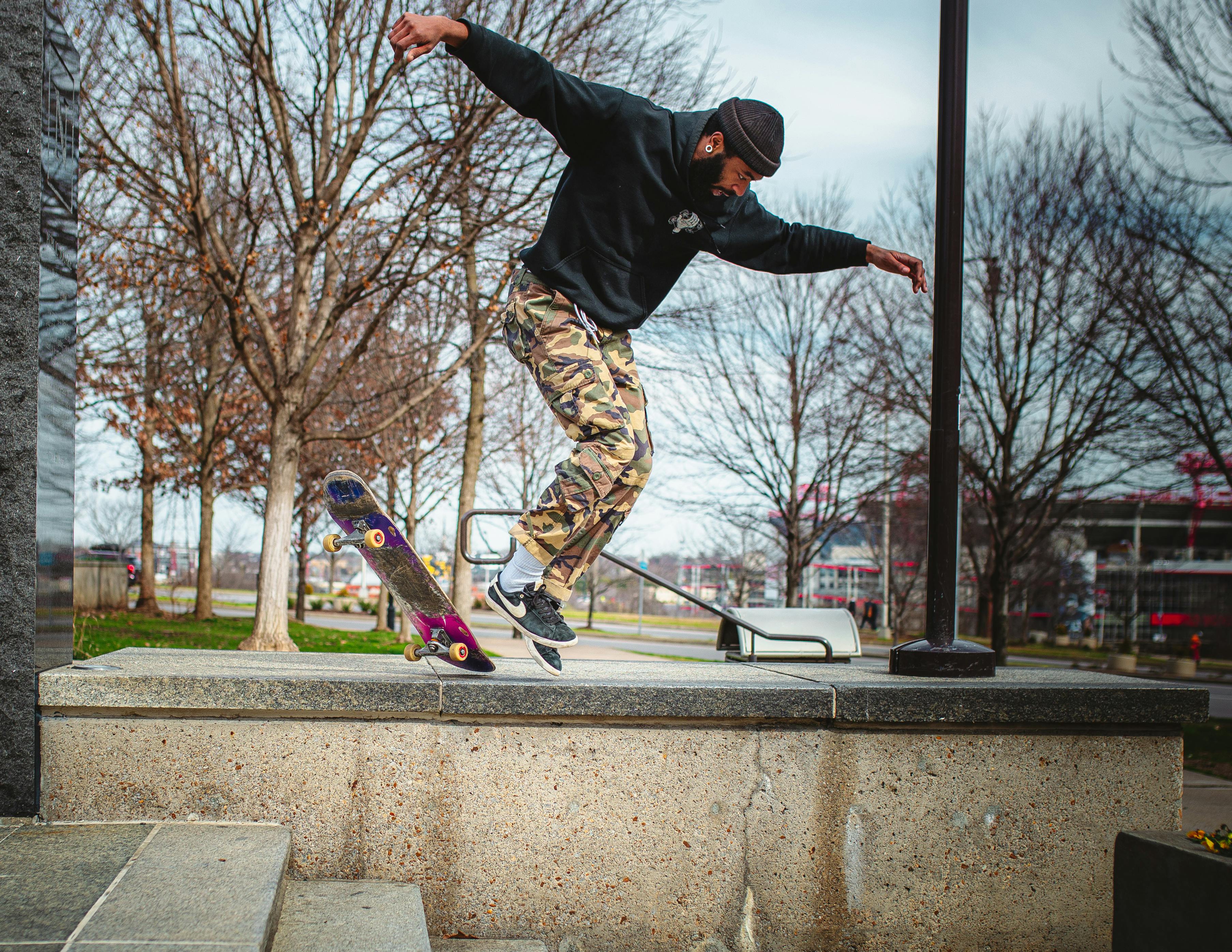 A skateboarder executing a trick in an urban park setting, showcasing athletic skill and street style.
