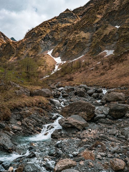 Free A tranquil stream flows through a rocky mountain landscape in Glarus Süd, Switzerland. Stock Photo