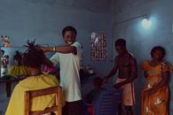 Barber shop in Togo with people engaged in hairdressing activities, creating vibrant atmosphere.