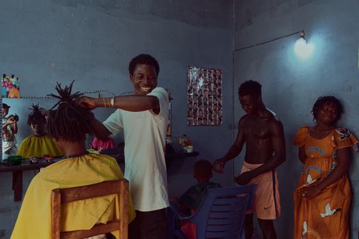 Barber shop in Togo with people engaged in hairdressing activities, creating vibrant atmosphere.