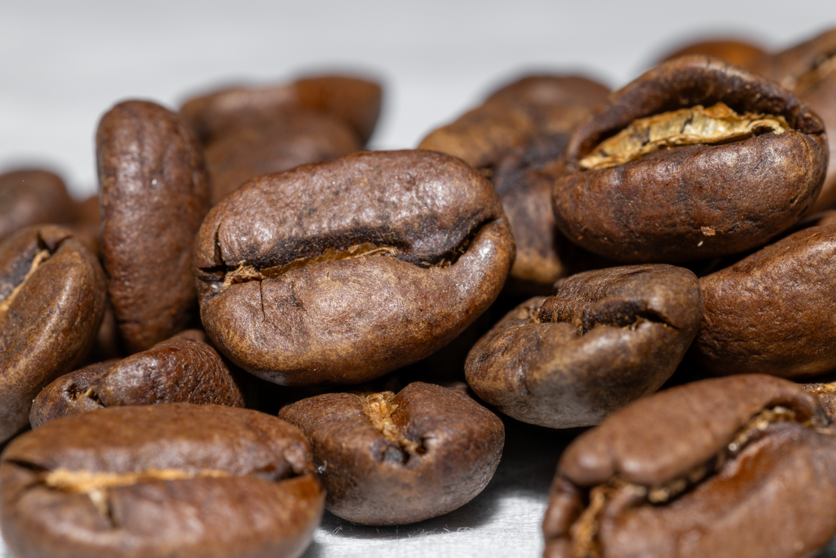 Macro photograph of glossy roasted single-origin coffee beans.