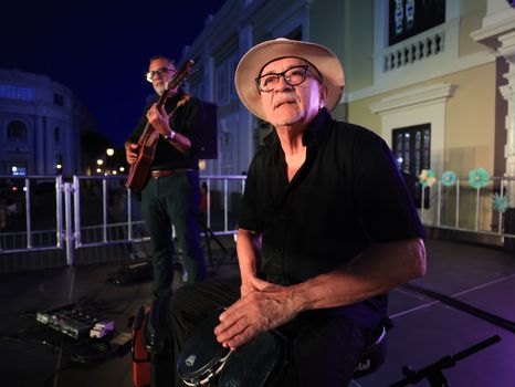 Two musicians perform live on stage at an outdoor festival, capturing the nightlife ambiance.