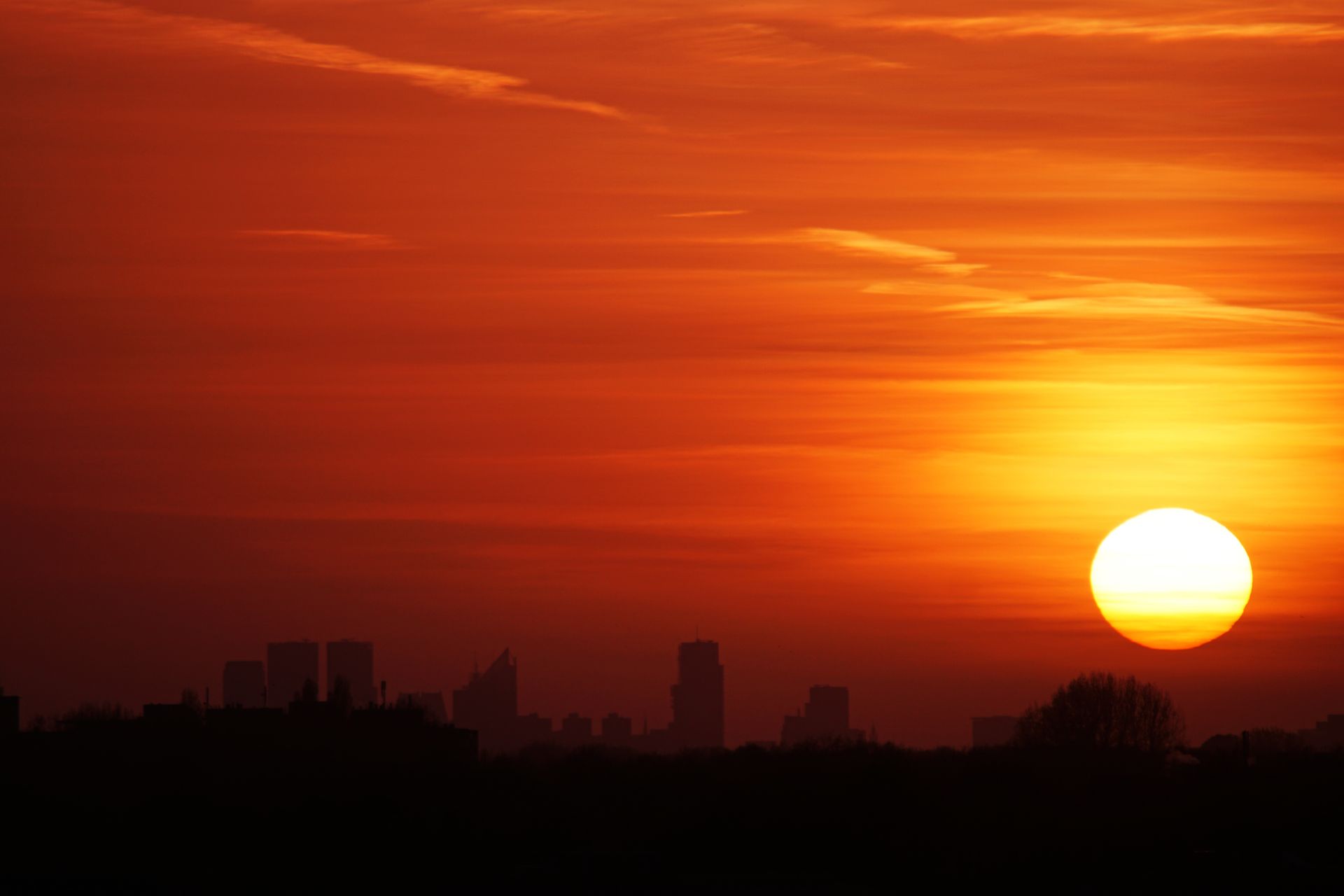 A stunning silhouette of a city skyline against a vibrant sunset.