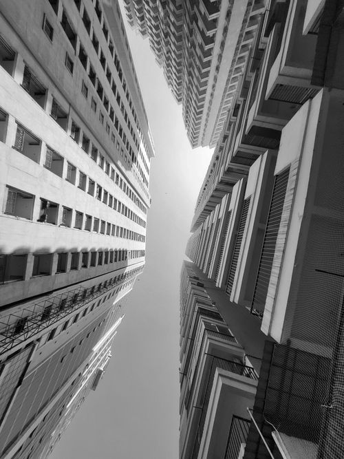 Free Black and white view of towering skyscrapers with dramatic angles capturing urban architecture. Stock Photo