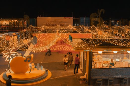 A lively night market scene in Port City Colombo, adorned with twinkling lights and bustling crowds.