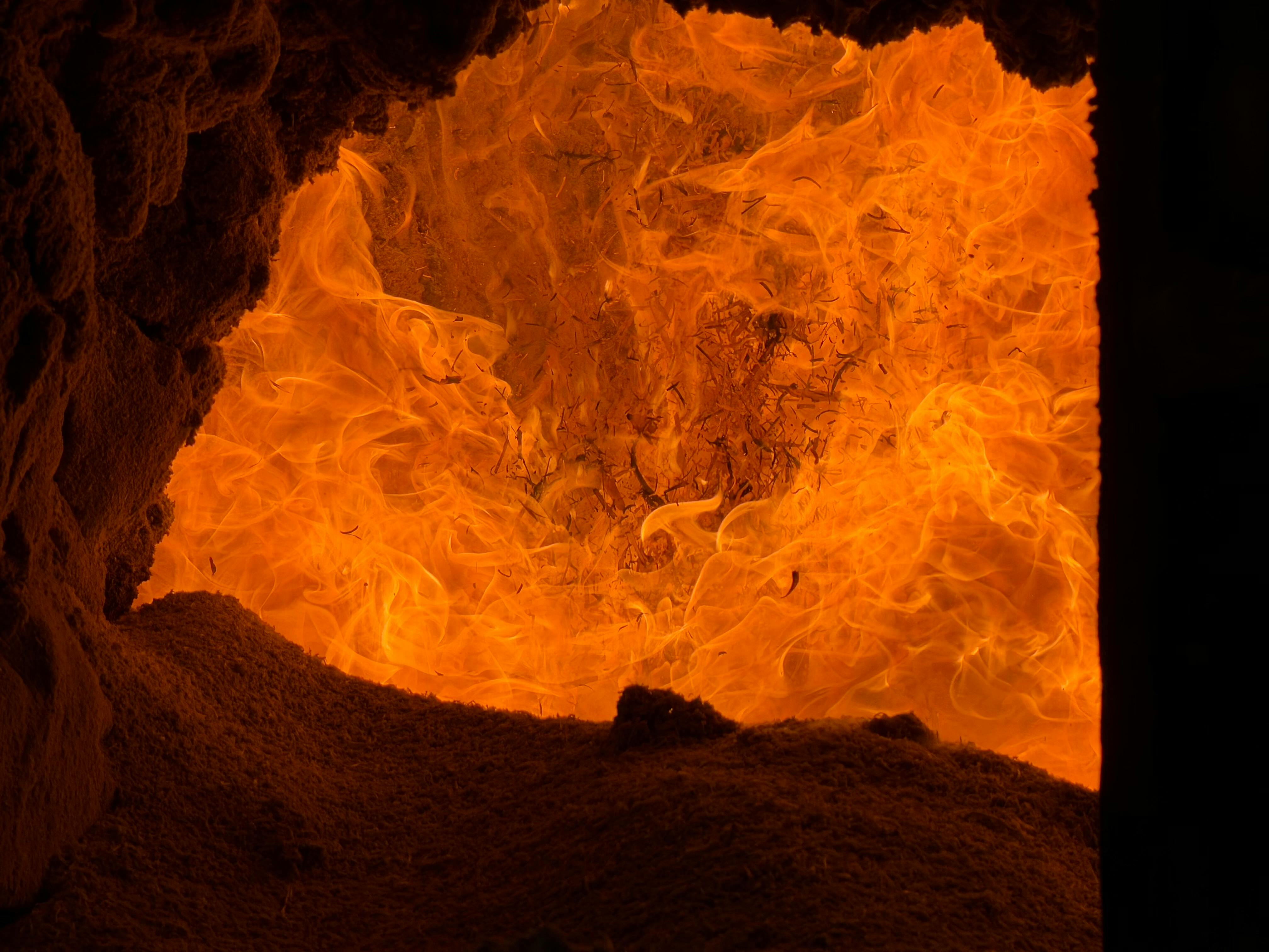 Intense orange flames inside an industrial refractory-lined furnace — showing the operating environment these ceramic bricks must endure