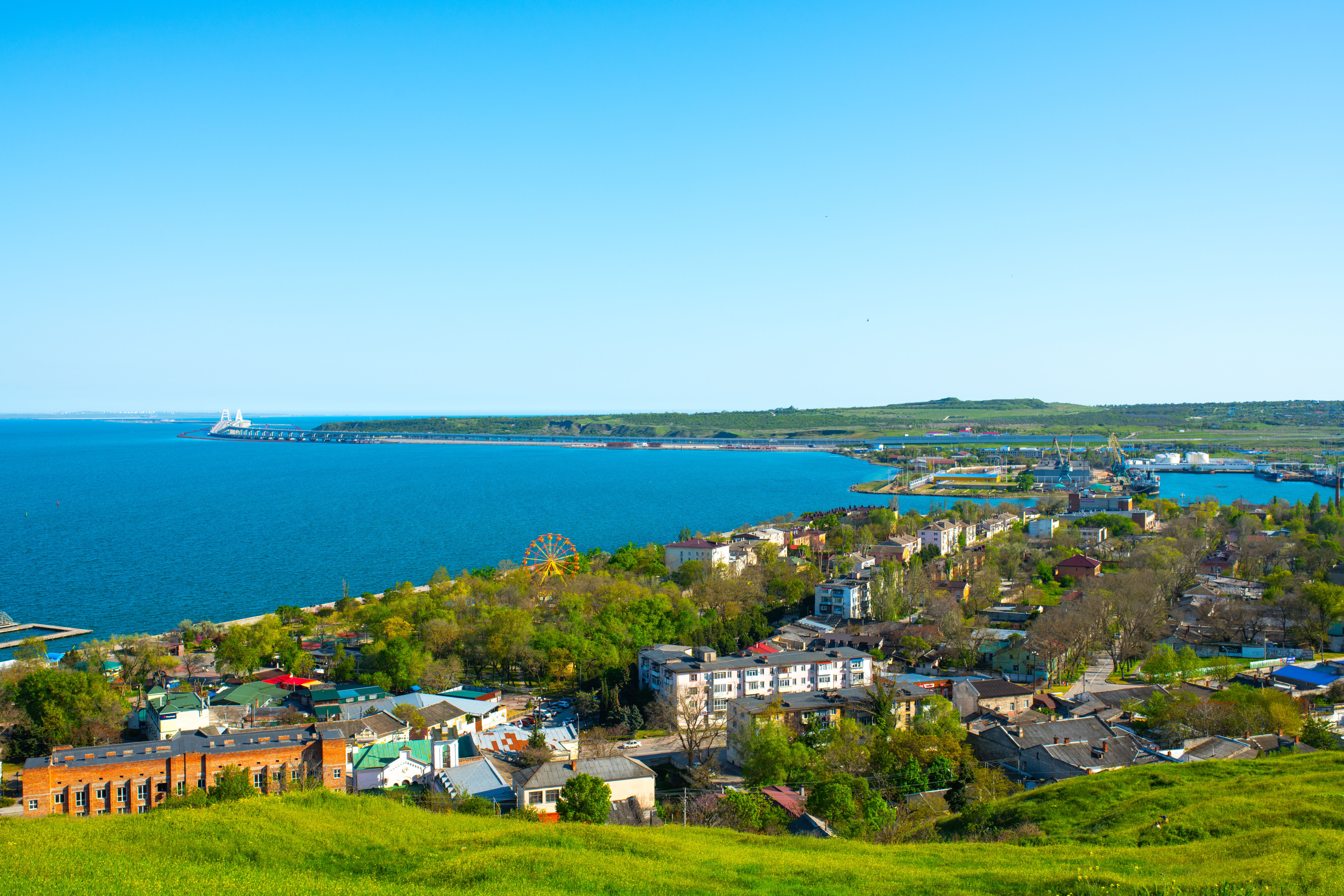 Aerial view of Kerch cityscape with vibrant greenery and blue waters under a clear sky. (Photo by Oleksiy Yeshtokyn,🌻🇺🇦🌻 on Pexels)