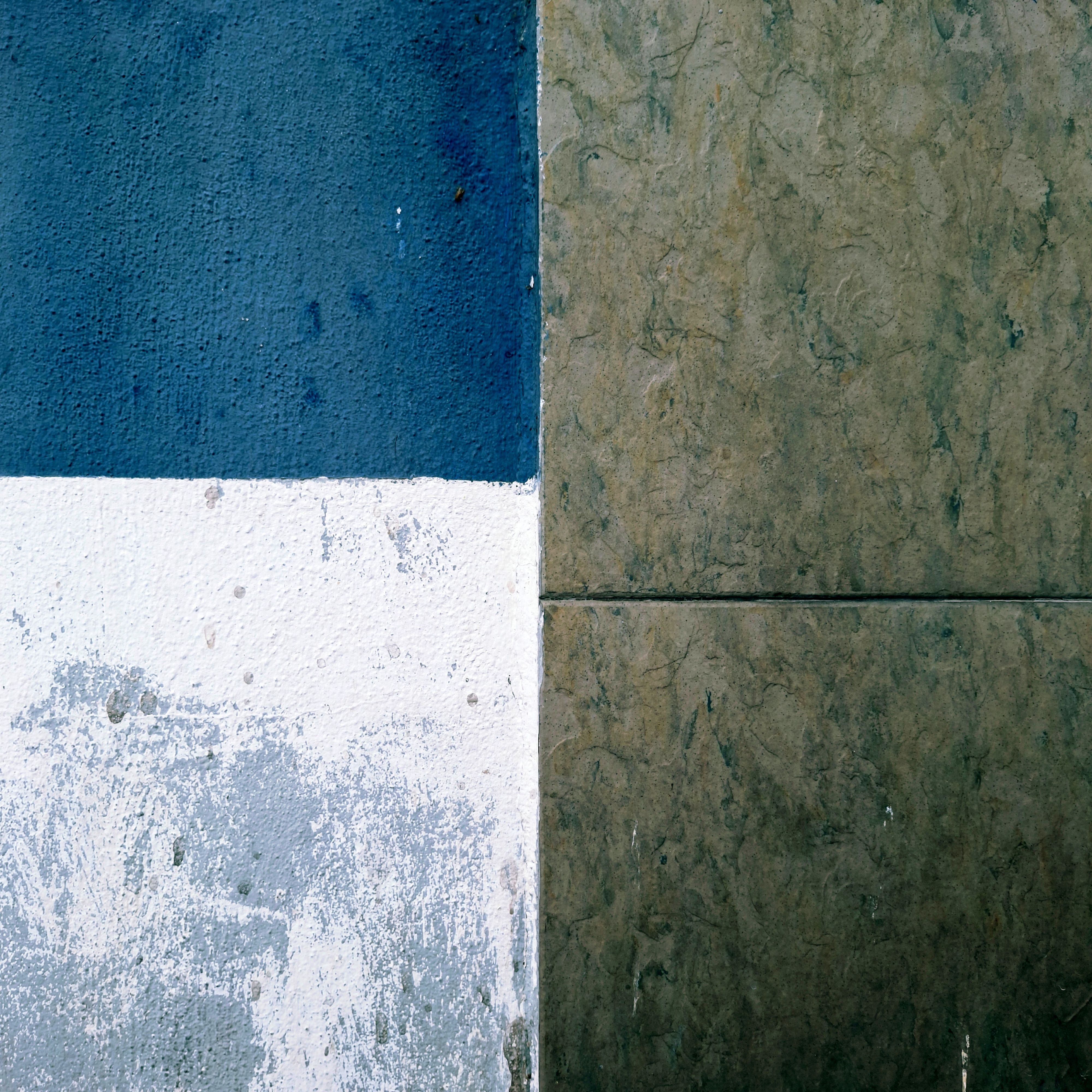 Close-up of blue and beige textured urban wall in Ipoh, capturing the beauty in simplicity.