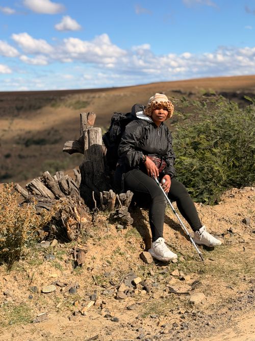 Free A hiker taking a break in the picturesque Lesotho Highlands under a clear blue sky. Stock Photo