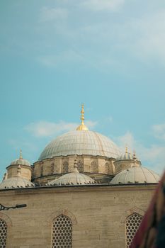 Elegant dome of a historic mosque in Istanbul, showcasing Ottoman architecture against a blue sky.