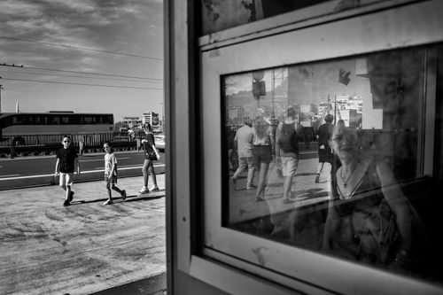 Free Black and white street scene capturing pedestrians and reflections in a cityscape. Stock Photo