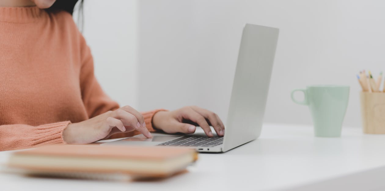 Person Using Silver Macbook on White Table