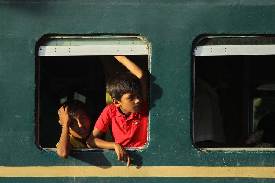 Two young boys look out from a train window, capturing a moment of curiosity and travel.