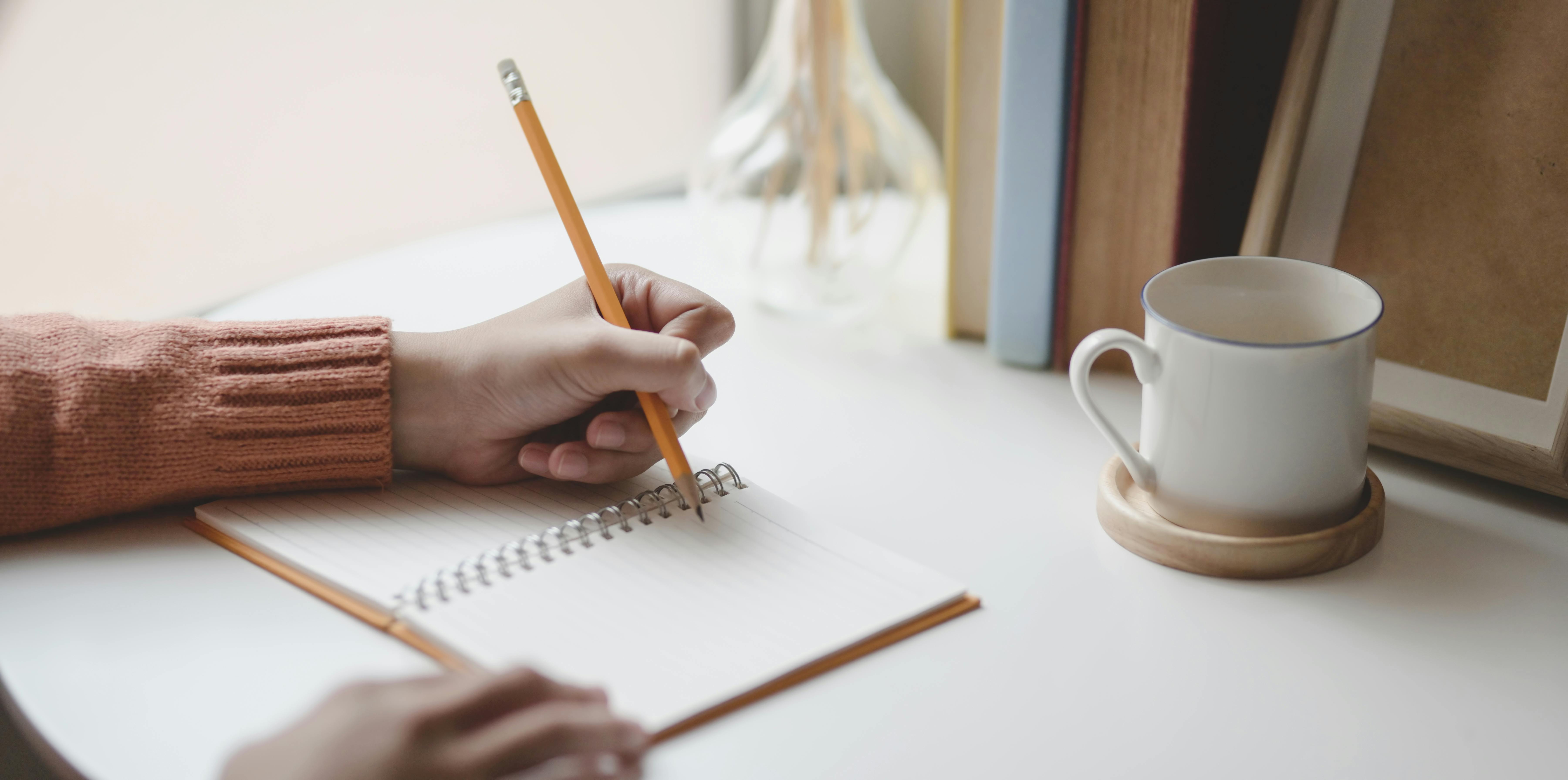 Female worker writing thoughts in notepad