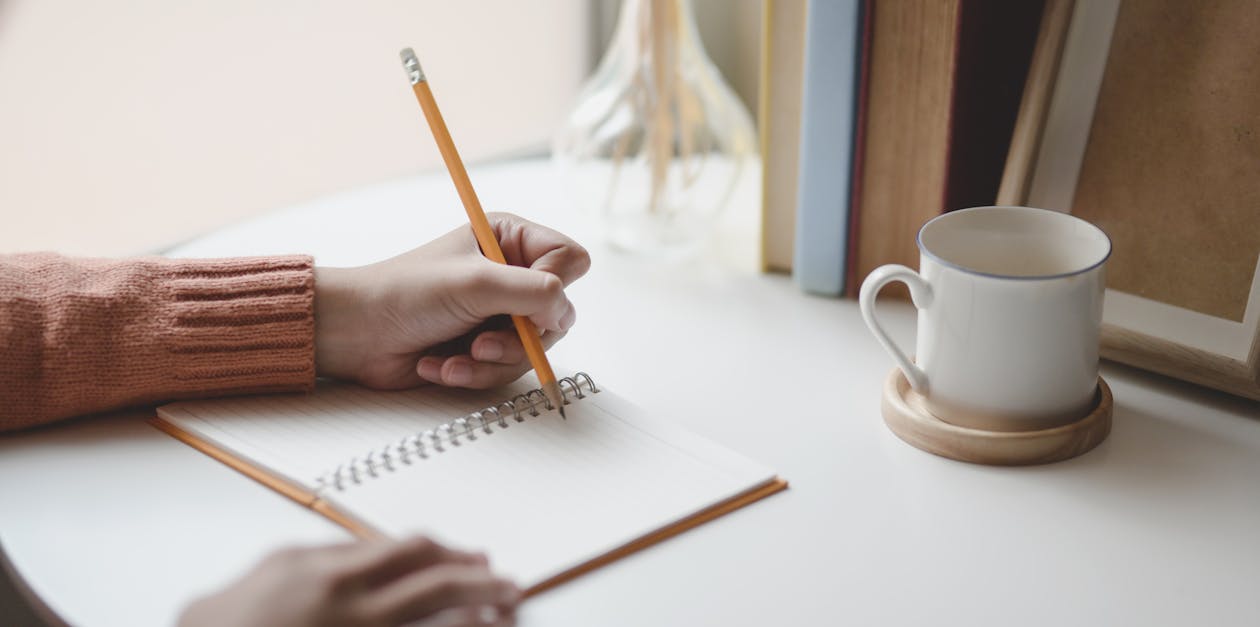 Female worker writing thoughts in notepad