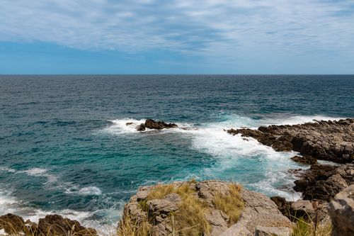 Free Explore the vibrant blue sea and rocky shore of Palermo, Sicily's stunning coastal scene. Stock Photo
