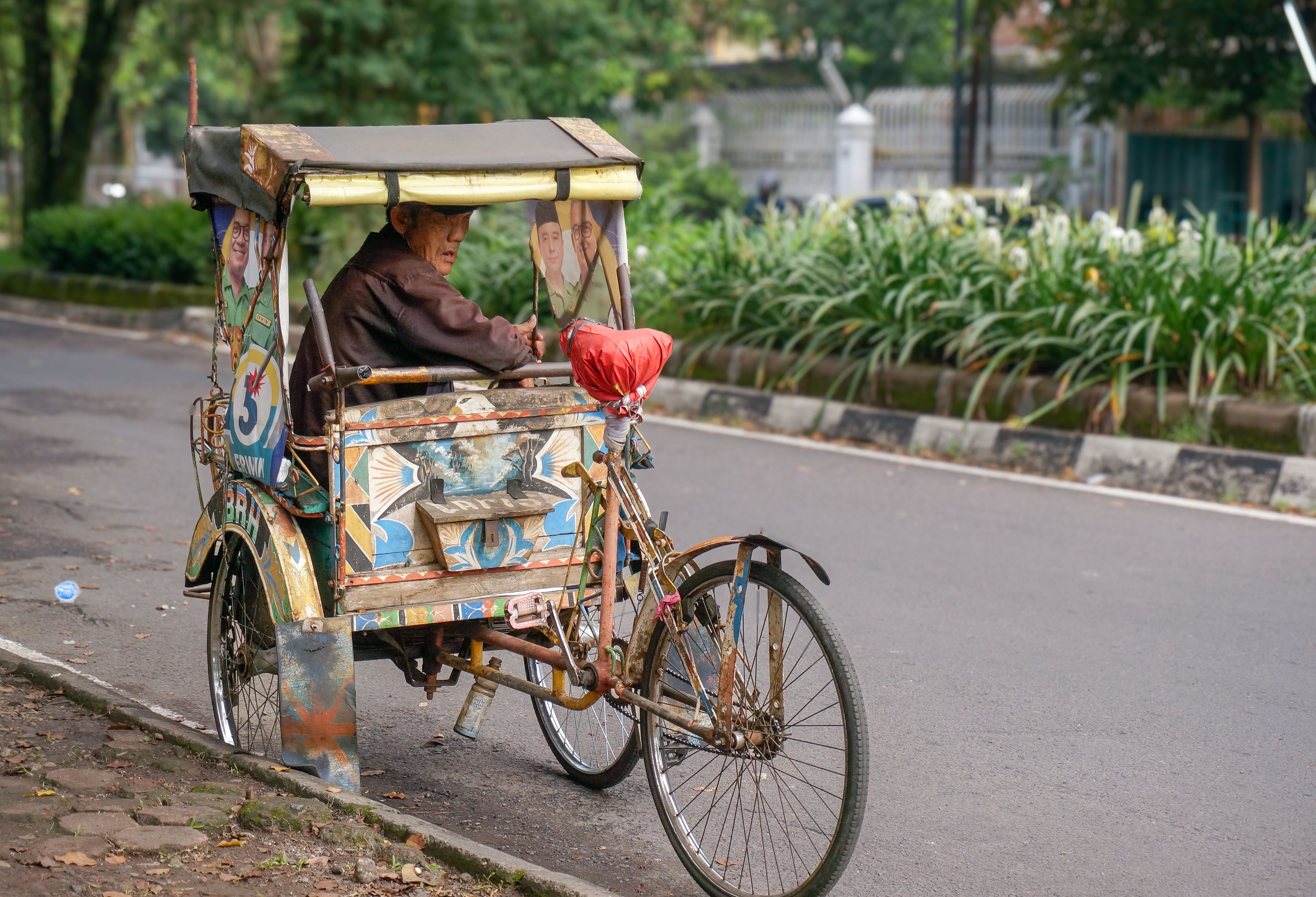 Man Riding Traditional Rickshaw in Urban Street · Free Stock Photo