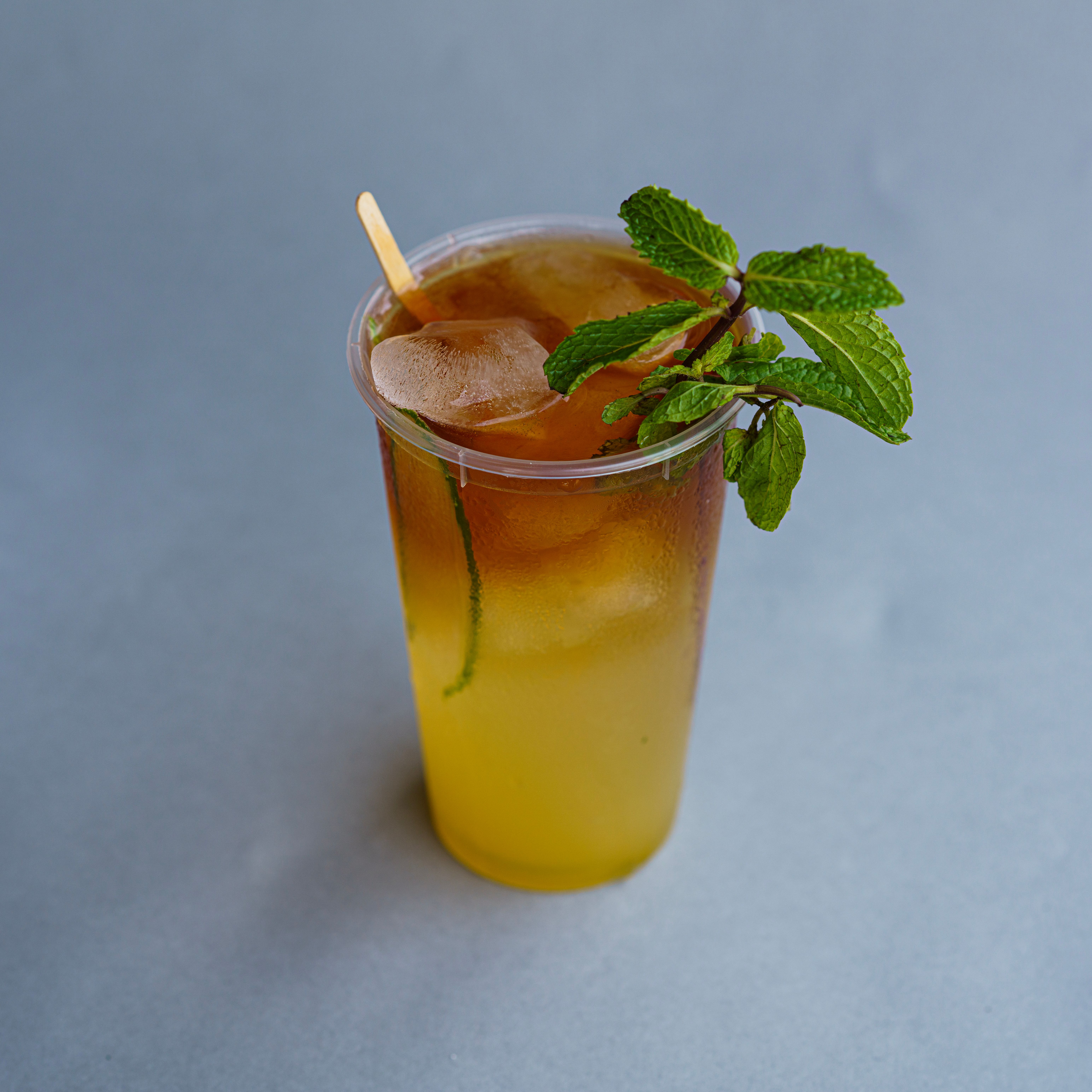 A glass of iced tea with lemon and mint, perfect for a refreshing summer drink.
