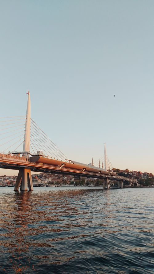 Free A stunning cable-stayed bridge spans the water at golden hour, showcasing architectural beauty. Stock Photo