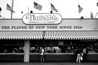 Black and white photo of Nathan's Famous, a New York City icon, with American flags.