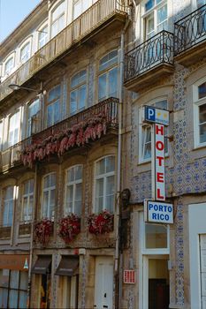 Elegant facade of a historic hotel in Porto, adorned with floral balconies and classic tiles.