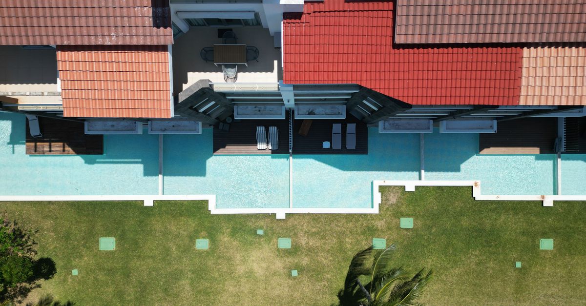 Top-down view of a luxury home with a swimming pool, lush garden, and vibrant rooftop.