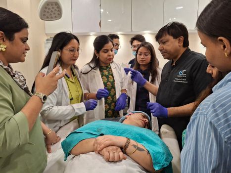 Dermatologists in training perform a procedure under supervision in a clinical setting.
