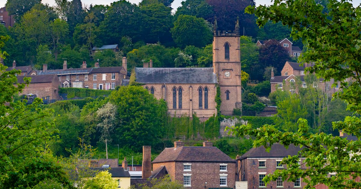 A picturesque view of St. Luke's Church and surrounding greenery in Ironbridge, England.