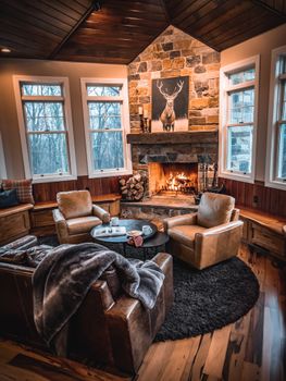 Warm and inviting living room with a fireplace, leather chairs, and a scenic view, perfect for relaxation.