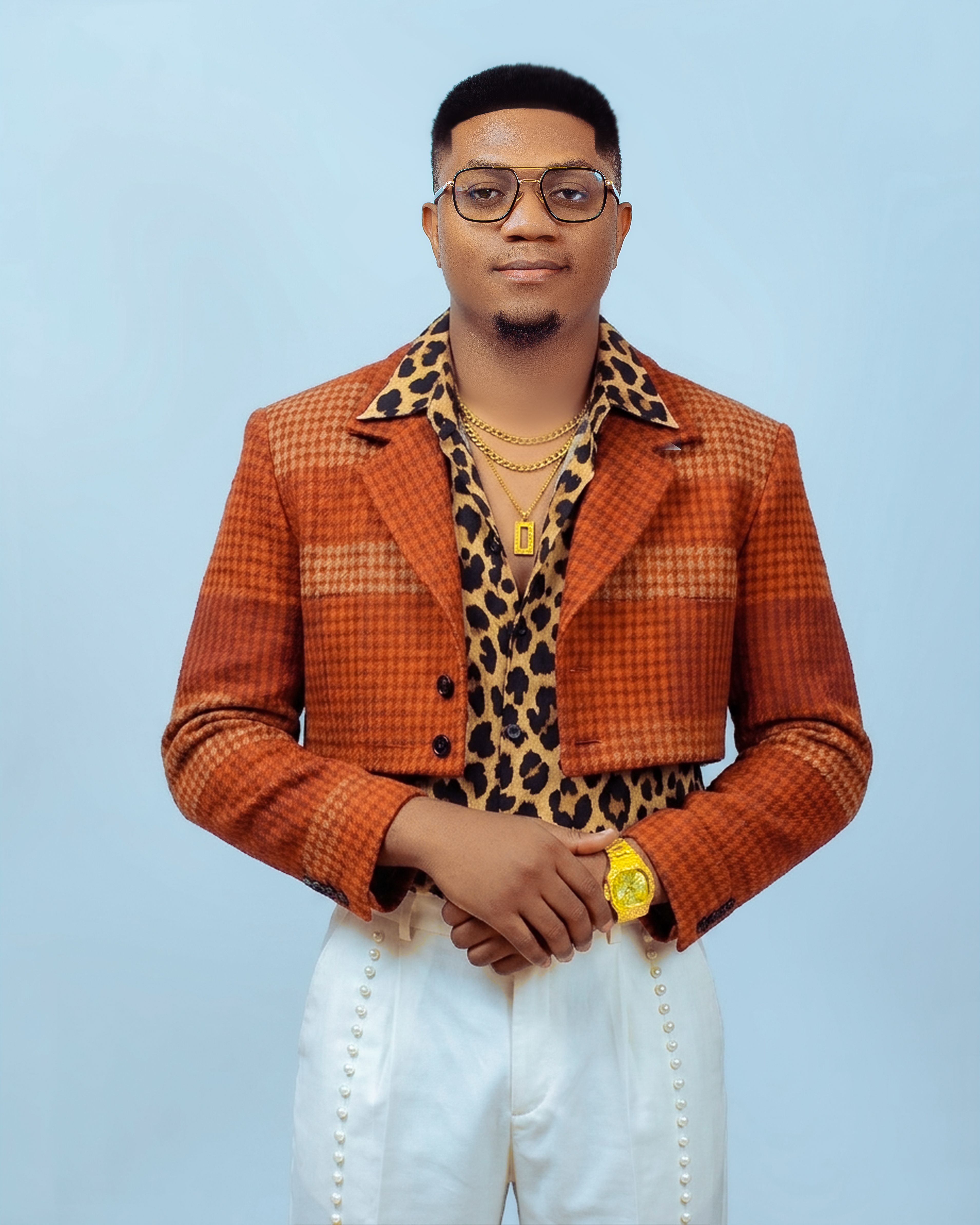 Portrait of a stylish man in vintage plaid and leopard print with gold accessories.