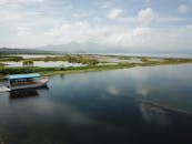 宁静的船只在洪都拉斯反光湖上航行，四周环绕着郁郁葱葱的风景