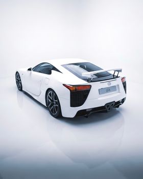 Sleek white sports car displayed in a bright studio environment.