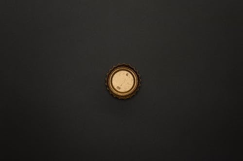 Gold Round Bottle Top on Black Surface