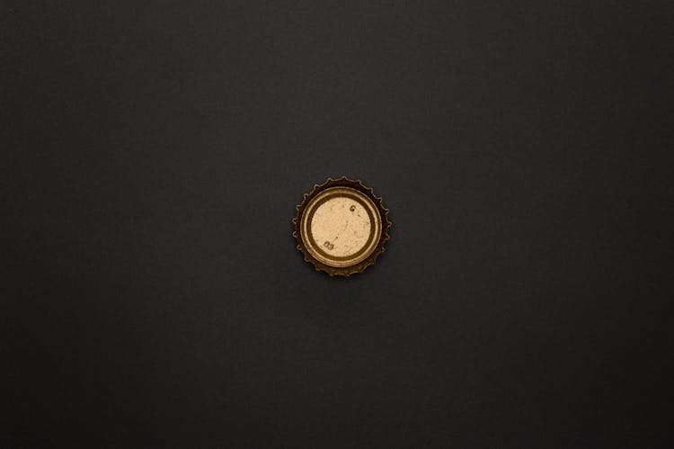 Gold Round Bottle Top On Black Surface