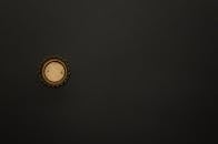 金色瓶盖的黑色表面极简图像，提供了充足的复制空间